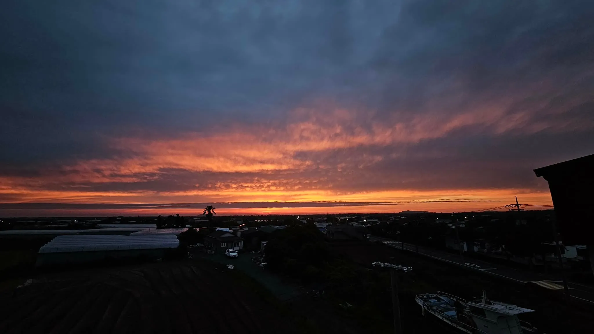 Evening over Jeju — the sky in bands of ember and slate