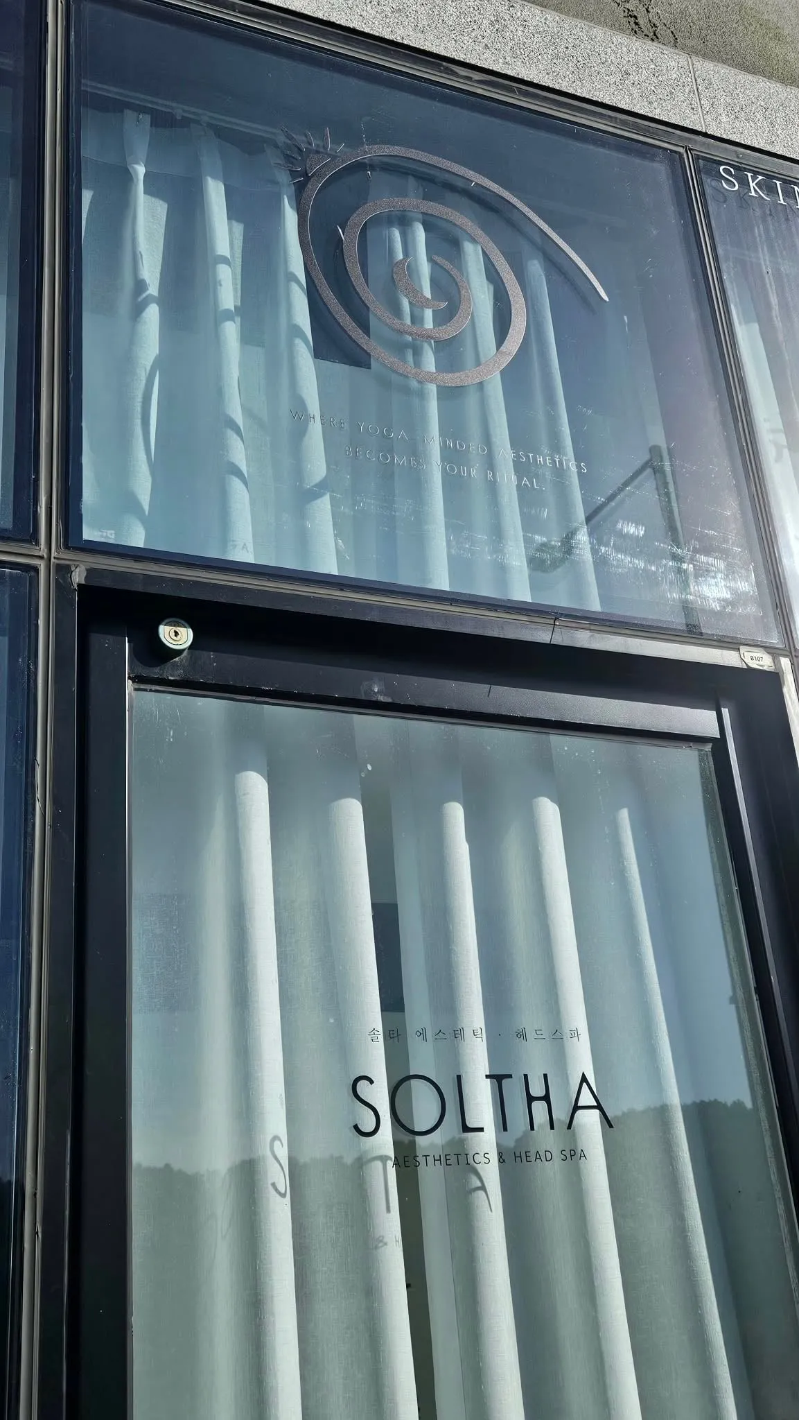 The SOLTHA spiral on the studio window — where yoga-minded aesthetics becomes your ritual